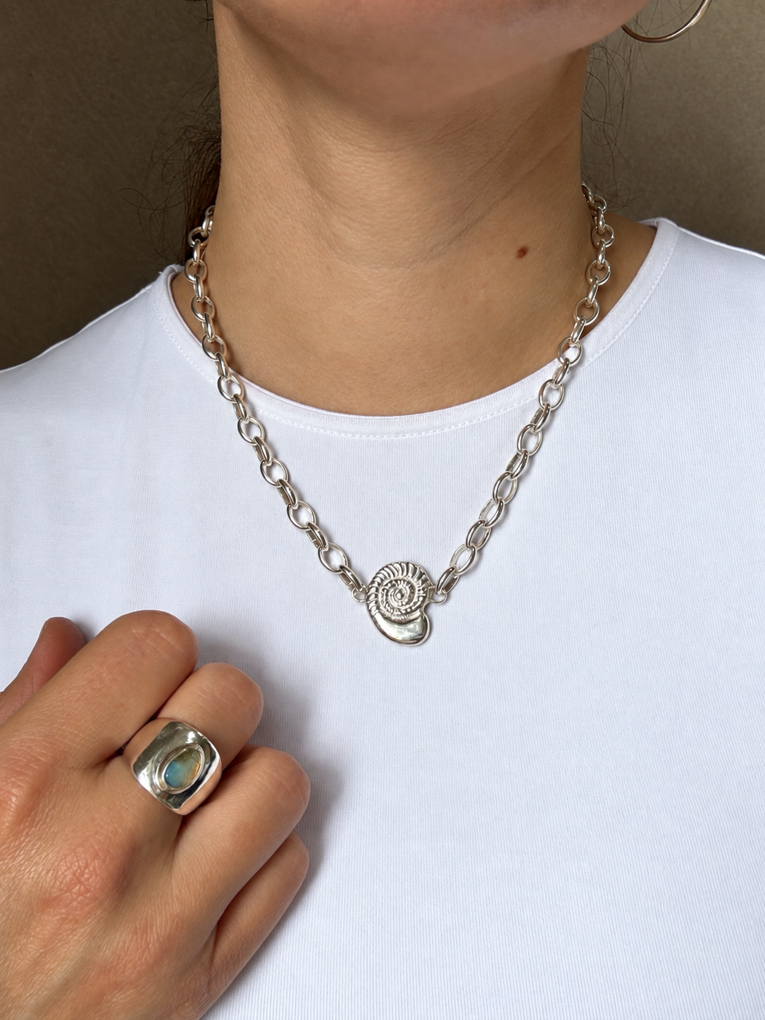 Lucky Shell Talisman Necklace worn on a model in sterling silver, the shell charm resting on a chunky chain